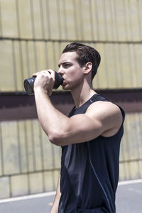 Side view of young man exercising in gym