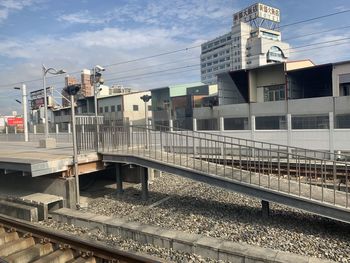 Train at railroad station in city against sky