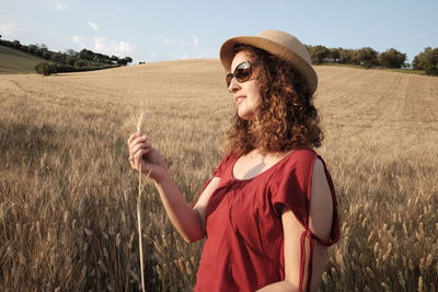 Woman holding crop on field