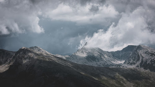 Panoramic view of snowcapped mountains against cloudy sky