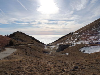 Road leading towards mountain against sky