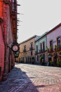 Street amidst buildings against clear sky