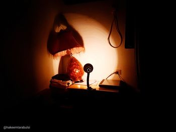 Electric lamp on table against wall at home