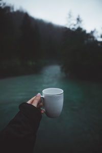 Cropped hand holding coffee cup