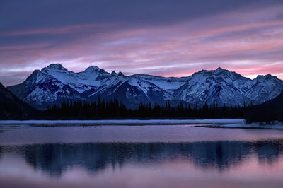 Scenic view of lake and mountains against sky during sunrise