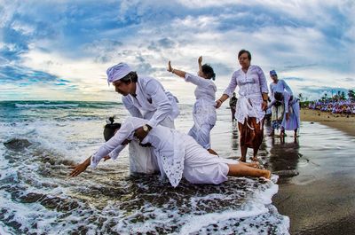 People at beach against sky