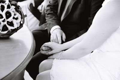 Midsection of couple sitting in hands