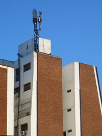 Low angle view of buildings against clear blue sky