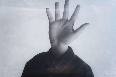 Cropped hand touching glass window