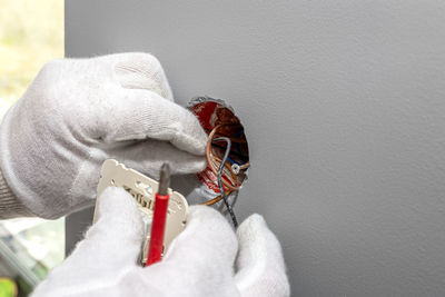 Close-up of hands working against wall