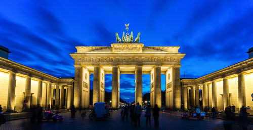 Low angle view of illuminated brandenburg gate against cloudy sky