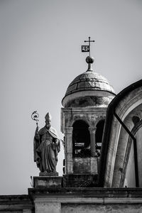 Human statue against dome of church