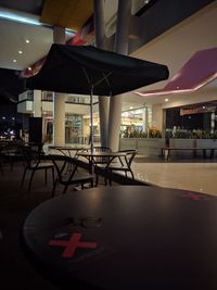 Empty chairs and tables in restaurant at night