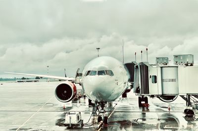 Airplane on airport runway against sky