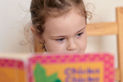 Curious young girl reading a book, amused