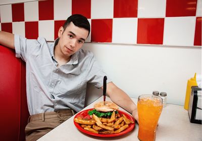 Portrait of young man sitting at table in cafe