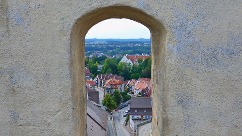 Buildings in town against sky seen through window