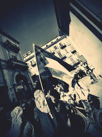 Low angle view of people on street against buildings in city