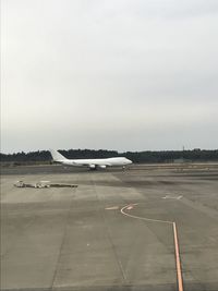 Airplane on runway against sky