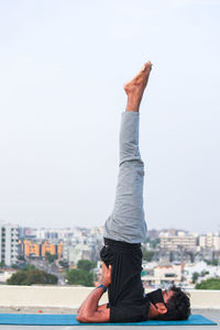 Midsection of man with arms raised against sky