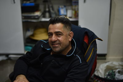 High angle portrait of smiling man sitting on chair