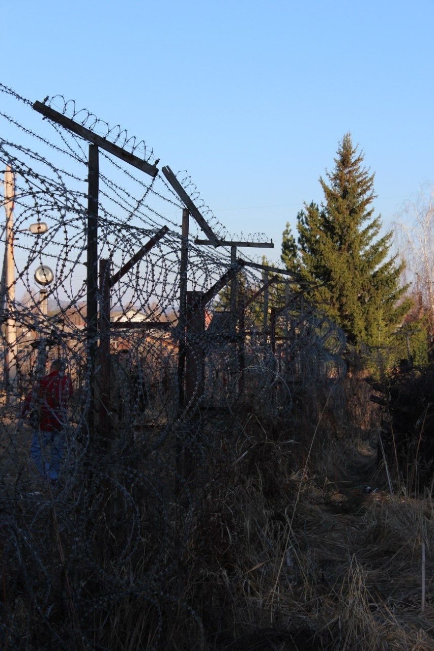 clear sky, built structure, architecture, abandoned, building exterior, field, obsolete, house, damaged, copy space, tree, fence, run-down, sky, outdoors, no people, deterioration, connection, rural scene, plant