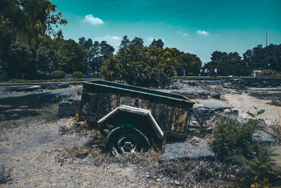 Abandoned car on field against sky