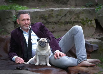 Man with dog on a dark brown fur.