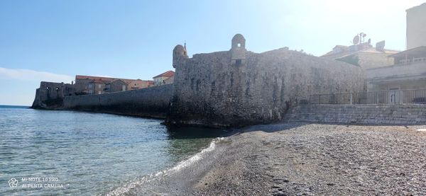 Historic building by sea against sky