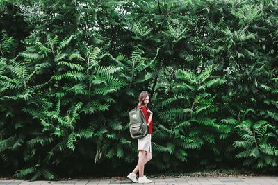 Full length of woman standing on tree trunk