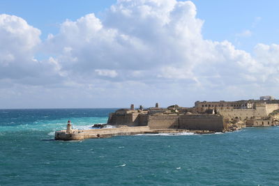 Scenic view of sea and buildings against sky