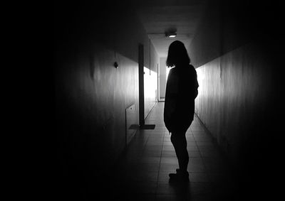 Rear view of woman walking in corridor of building