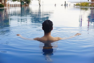 Rear view of man swimming in water