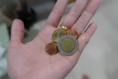 High angle view of hand holding coins