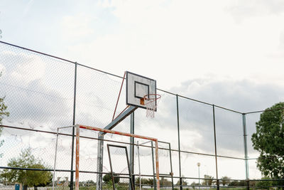 Low angle view of chainlink fence against sky