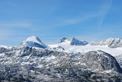 Scenic view of snowcapped mountains against blue sky