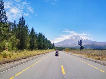 Person riding bicycle by landscape on road