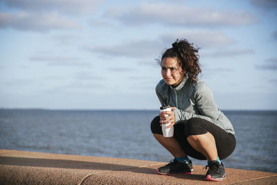 Girl squatting and drinking water