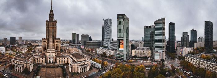 High angle view of buildings in city against cloudy sky
