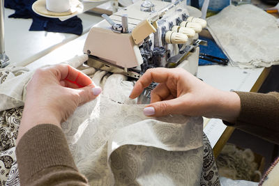 Cropped hand of woman sewing at factory