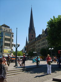 People on road in city against clear sky