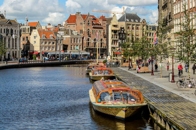 People on boat in city against sky