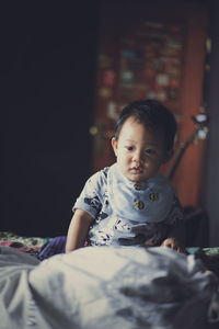 Boy sitting on bed at home