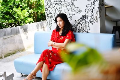 Young woman looking down while sitting outdoors