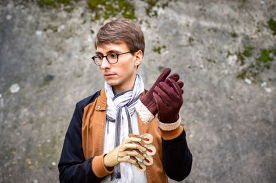 Portrait of a young man in drinking glasses outdoors