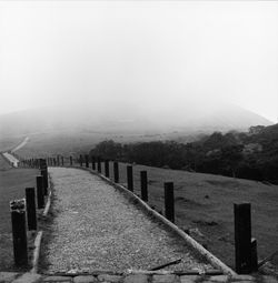 Wooden fence on mountain against sky