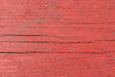 Red old wooden background with blue splashes with cracks. copy space. place for text. basis for