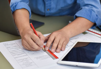 Midsection of man using laptop on table