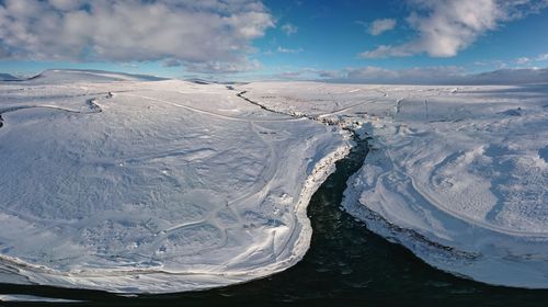 Aerial view of snowcapped mountains against sky