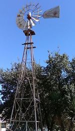 Low angle view of traditional windmill against clear blue sky